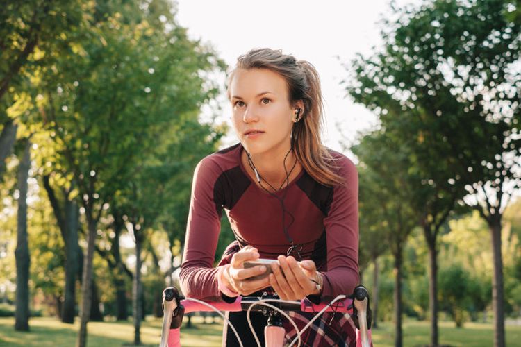 sport woman cycling with music